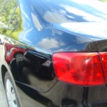 Before and after photographs of a damaged black Volkswagon Jetta that was repaired by Elite Paint & Body Shop in West Palm Beach, Florida.